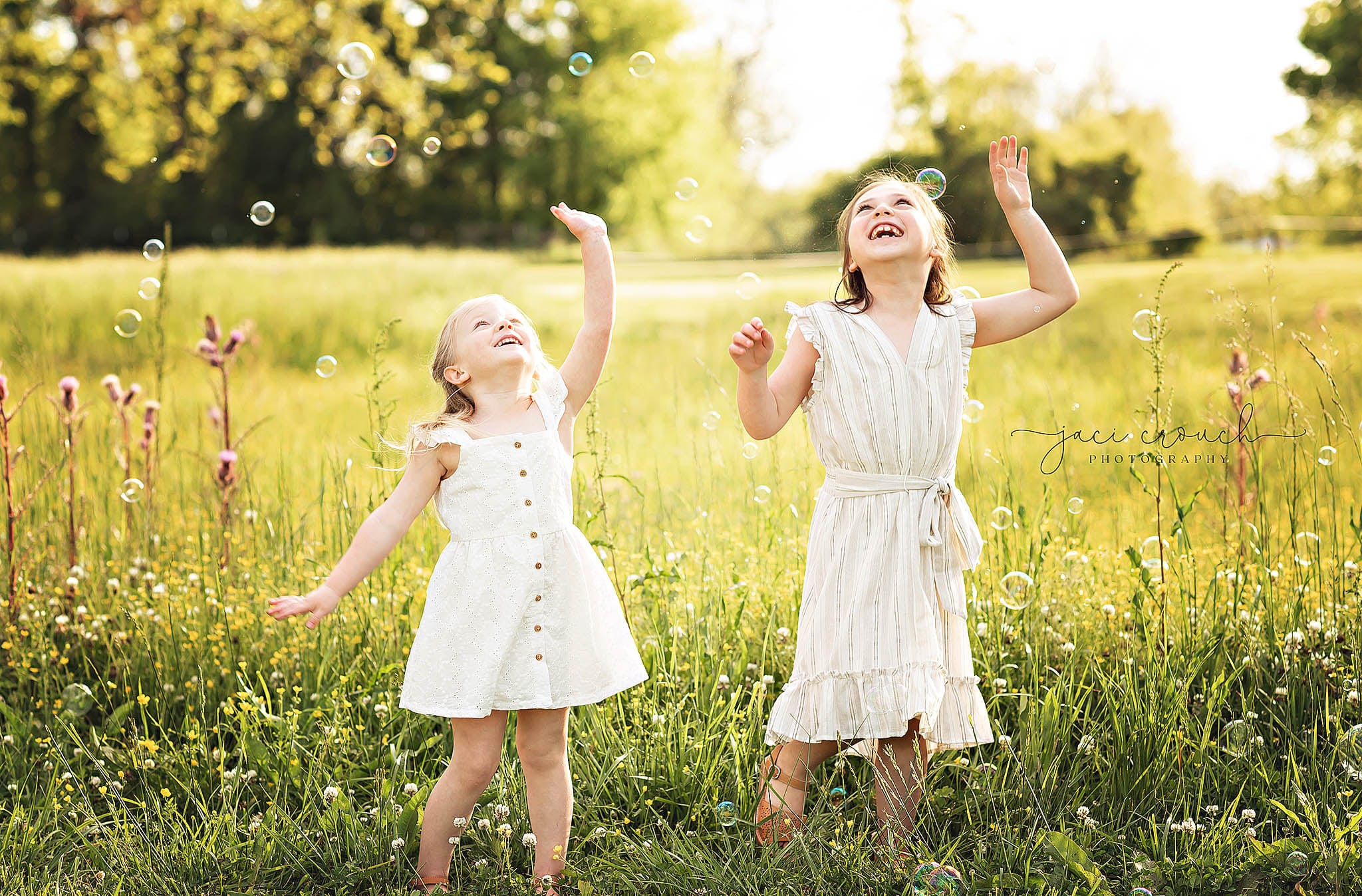 TWO PRETTY GIRLS PLAYING WITH BUBBLES